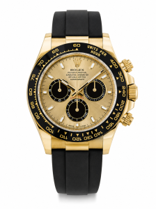 Rolex Daytona super clone yellow gold with champagne dial and black ceramic bezel held in hand next to green Rolex presentation box showing real product detail and finishing.